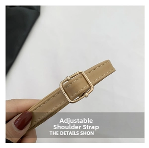 Detail view of the adjustable synthetic leather shoulder strap with golden metal buckle