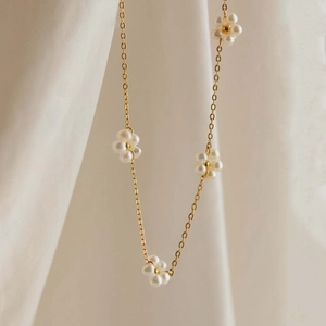Elegant gold-plated stainless steel necklace featuring delicate white pearl flower charms