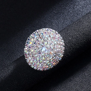 Macro shot of silver geometric ring with iridescent rhinestones on black leather stand
