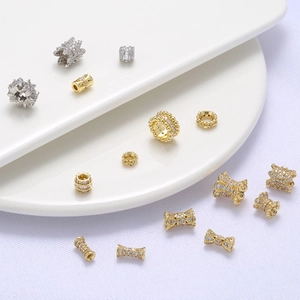 Gold and silver micro-pave zircon spacer beads for jewelry making on white fabric