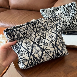 Detail of handmade linen cosmetic bags with intricate geometric and fish embroidery