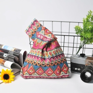 Detail of colorful geometric pattern and linen texture on Japanese wrist knot bag