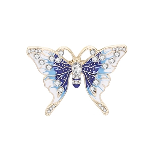 Detailed close-up of a butterfly brooch with gold plating, blue enamel, and crystals
