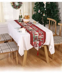 Close-up of festive Christmas table runner with reindeer patterns and red tassels