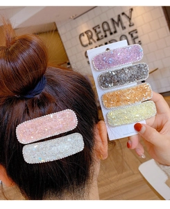 Detail showing set of six candy-colored crystal hair clips worn and on display card