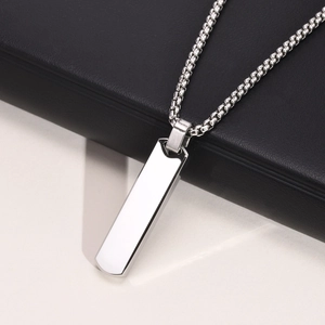 Close-up of a polished silver stainless steel bar pendant with box chain on contrast background