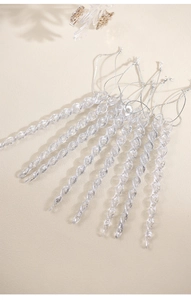 Close-up of transparent acrylic spiral icicle ornaments with silver hanging strings