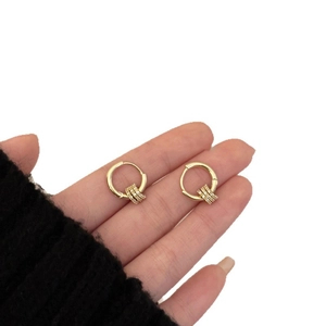 18k gold plated hoop earrings with three zircon pendants held against a white background