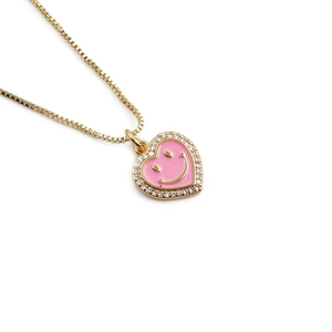 Pink enamel heart necklace with golden smiley face and zircon border on gold chain