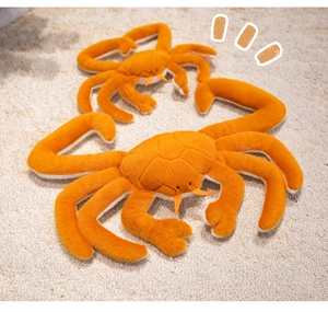 Detail showing two orange plush king crabs in different sizes on a soft white carpet