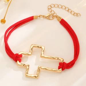 Adjustable red suede cord bracelet featuring a gold hollow cross charm with hammered texture