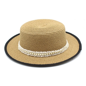 Detail of flat top straw boater hat with white lace trim and faux pearl embellishments
