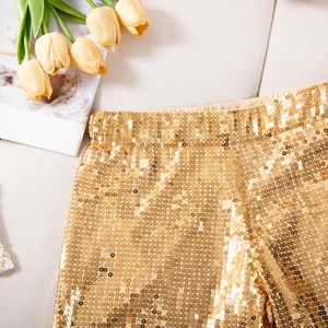 Detailaufnahme der goldenen Pailletten-Struktur und Gummizug an High Waist Shorts