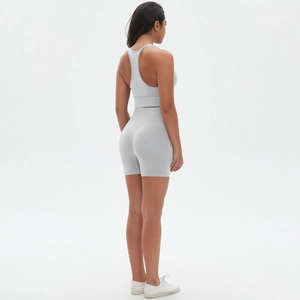 Dettaglio del reggiseno sportivo grigio con schiena a vogatore e pantaloncini a vita alta