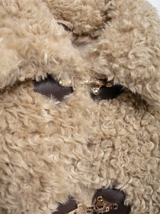 Macro detail of khaki fleece texture with dark brown leather trim and golden metal buckle