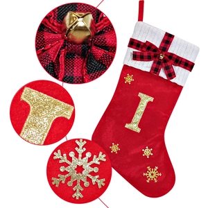 Detail of red velvet Christmas stocking with gold glitter letter and knitted white cuff