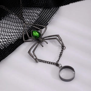 Detailed view of gothic gunmetal spider hand chain with a pear-shaped green gemstone
