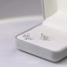 Macro shot of silver S925 sterling silver bow knot stud earrings in a velvet gift box