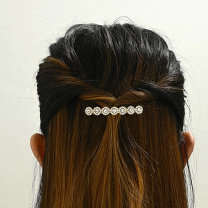 Detail of elegant gold hair clip with crystal sunflowers worn on a half-up hairstyle
