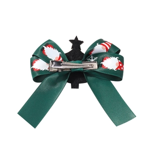 Dark green satin Christmas bow hair clip with snowflake patterns and metal alligator clip