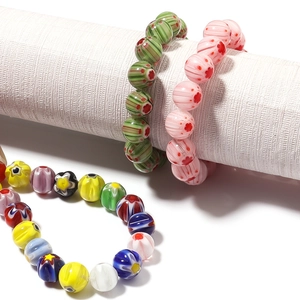Detailed close-up of handmade glass millefiori beads with intricate floral patterns
