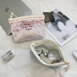Detailed view of embroidery on velvet cosmetic bags featuring rhinestones and daily beauty tools
