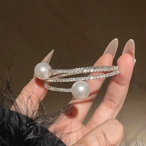 Close-up of a silver multi-layer spiral bracelet with white pearls and crystals
