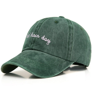 Close-up of vintage dark green washed cotton baseball cap with white embroidery