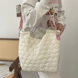 Détail du sac cabas matelassé blanc avec bandoulière rose et texture effet nuage