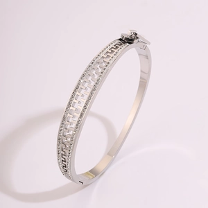 Detail of silver steel bangle with Greek fret pattern and sparkling zircon stones