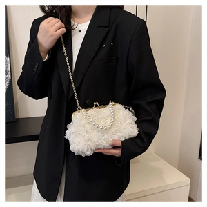 Détail de la pochette en dentelle blanche avec poignée en perles et chaîne dorée