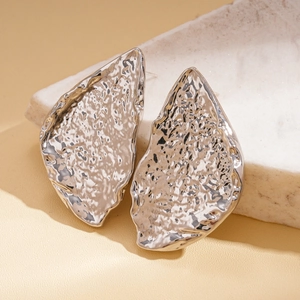 Close-up of silver hammered texture leaf earrings with irregular geometric metal folds