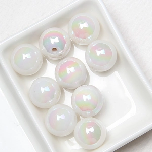 Detailed view of iridescent white acrylic beads in a white tray for DIY jewelry