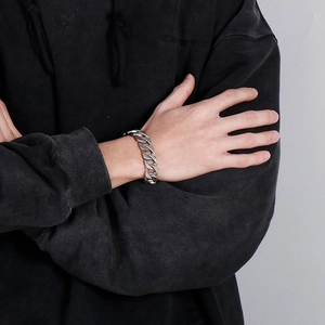 Close-up of a men's heavy silver stainless steel curb chain bracelet worn by a model