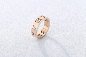 Detail view of rose gold hollow Roman numeral ring with polished metallic finish