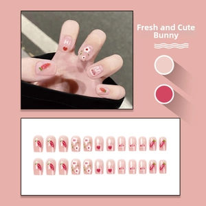 Detail view of pink press-on nails featuring cute carrot, rabbit, and floral patterns