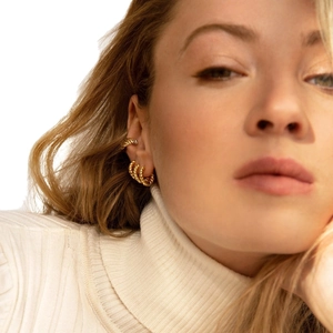 Minimalist gold twisted hoop earrings and ear cuff set worn by model in close-up shot