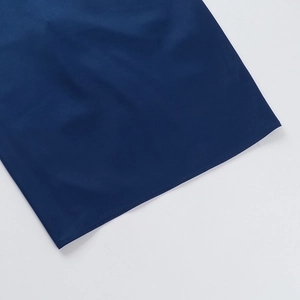 Détail de la texture en satin bleu foncé et des finitions soignées de l'ourlet