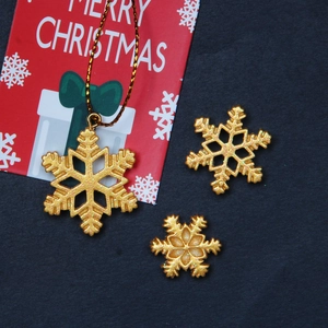 Detailed view of three golden glitter snowflake charms for DIY Christmas crafts and decor