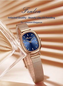 Detail of rose gold mesh band watch with deep blue sunray dial on elegant backdrop