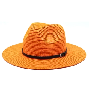 Detail of orange straw fedora with black leather band and metal buckle texture