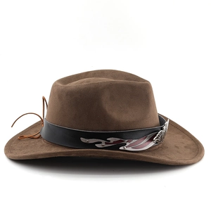 Detail of brown suede cowboy hat featuring black leather band and silver flame ornament