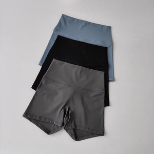 Dettaglio di pantaloncini da yoga a vita alta in tessuti blu, neri e grigi traspiranti