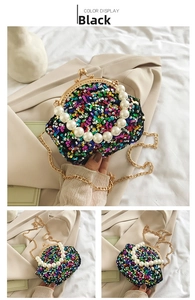 Detail of a sparkling black sequin mini bag with pearl handle and golden chain strap