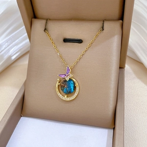 Macro view of golden butterfly necklace with starry blue gemstone in jewelry box
