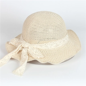 Détail d'un chapeau de paille beige avec élégant ruban en dentelle et tissage texturé