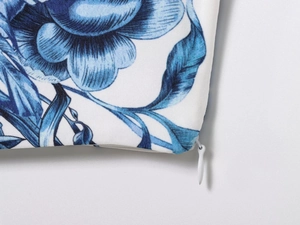 Close-up of white invisible zipper on fabric with blue floral print and fine texture