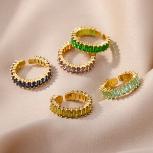 Detail view of five gold-plated adjustable rings with colorful baguette-cut zircons