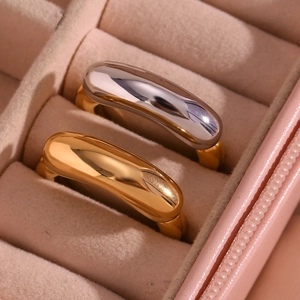 Close-up of two polished gold and silver tone titanium steel rings in a pink gift box