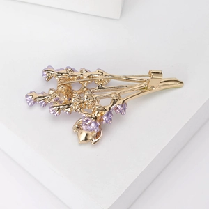 Elegant lavender brooch pin in purple and gold with secure pin back on white background